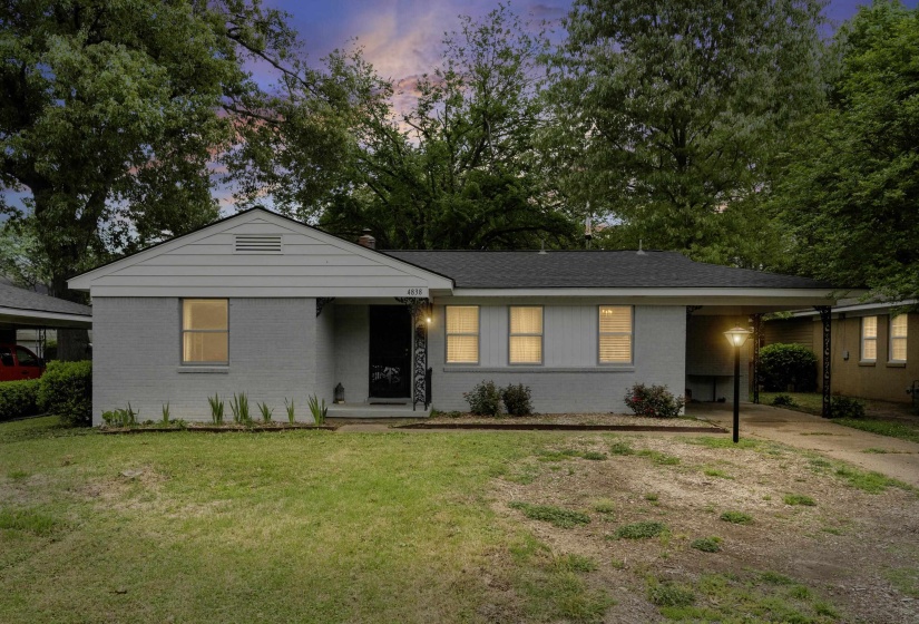 Single story home with brick siding, a lawn, an attached carport, and driveway