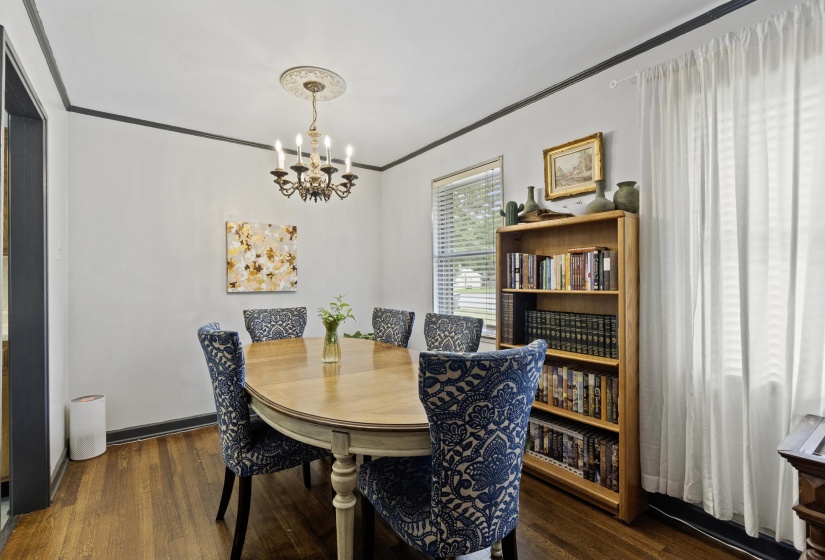 Dining room featuring ornamental molding, dark wood finished floors, and suspended lighting