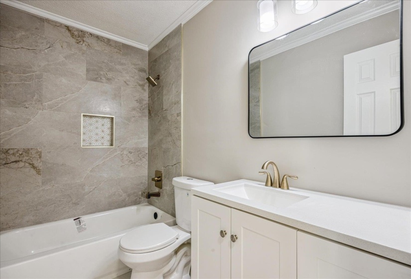 Full bathroom featuring vanity, crown molding, shower / bathtub combination, and a textured ceiling