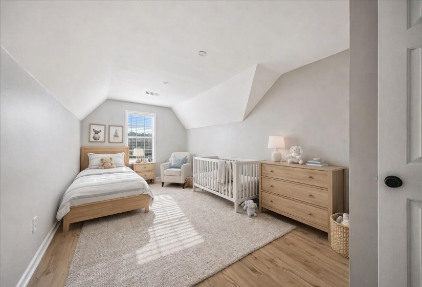 Bedroom with lofted ceiling and light wood-type flooring