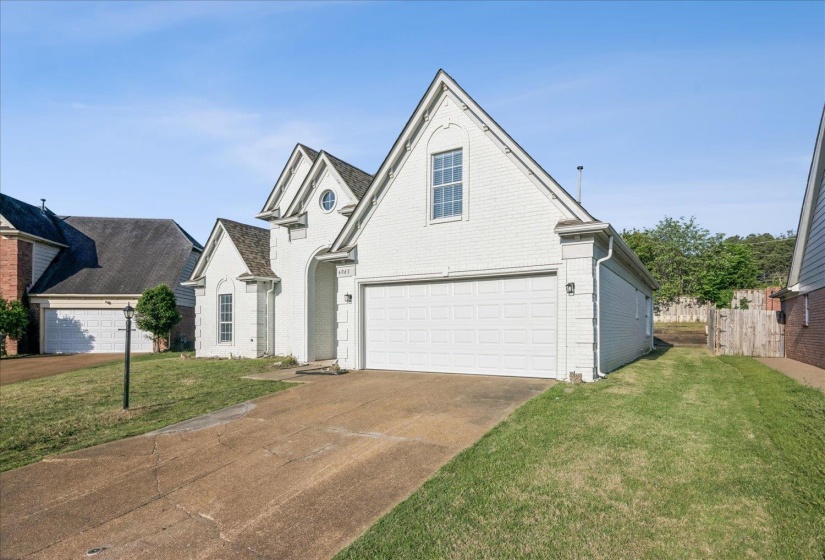 View of front of home featuring brick siding and concrete driveway