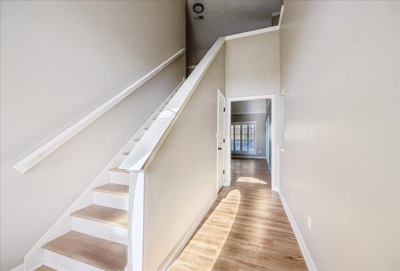 Staircase featuring wood finished floors and a high ceiling