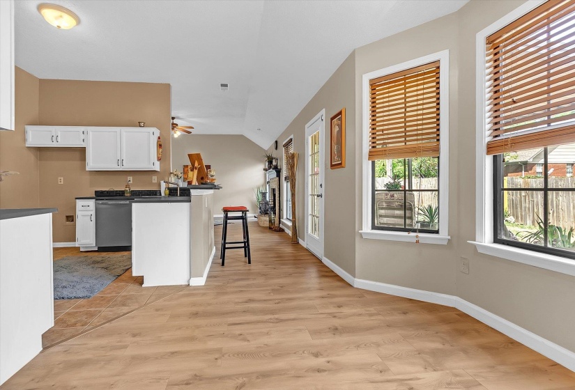 Kitchen with dark countertops, a kitchen breakfast bar, a peninsula, white cabinets, and light wood-style floors
