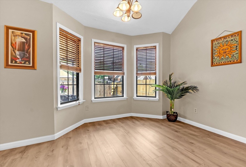 Unfurnished room featuring hanging lights and light wood-style flooring