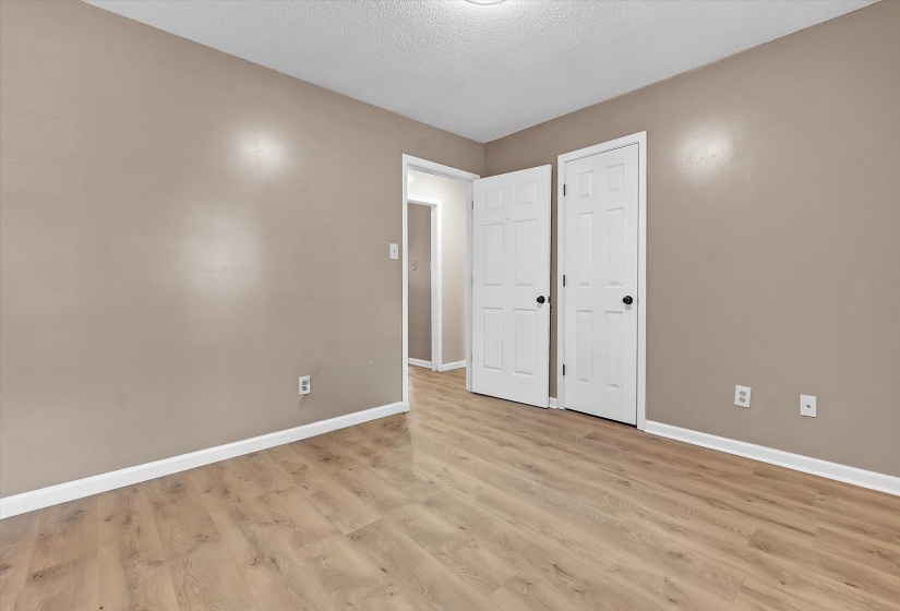 Unfurnished bedroom with a textured ceiling and light wood-type flooring