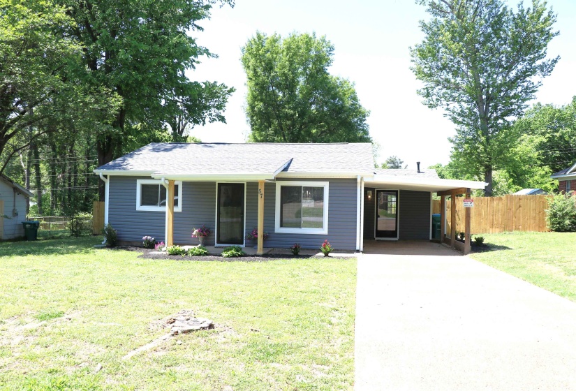 View of front facade with a carport, driveway, a shingled roof, and a porch