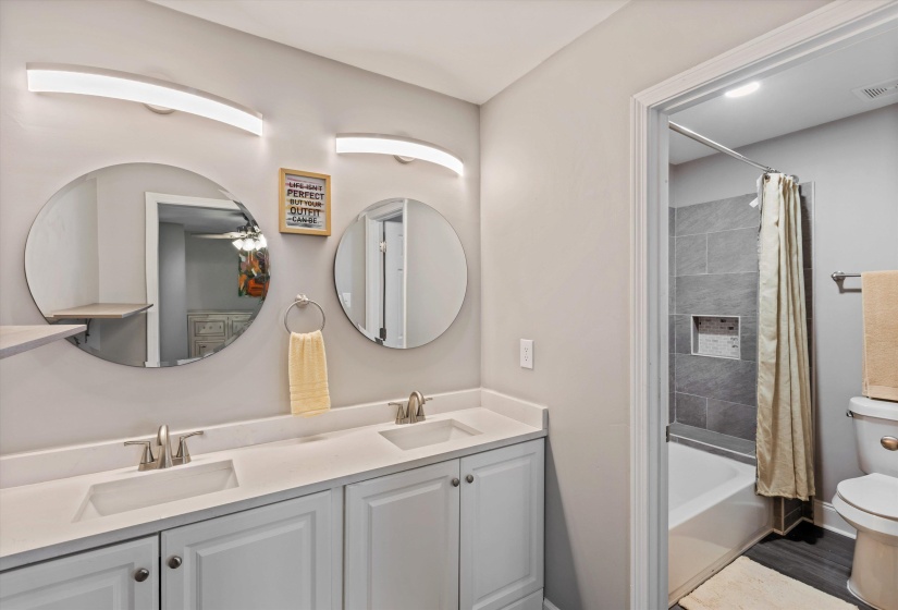 Full bath featuring double vanity and shower / tub combo