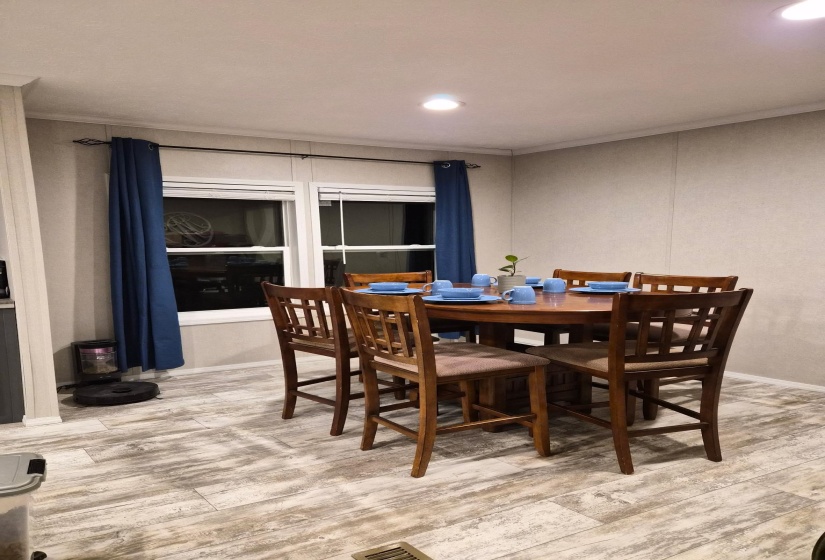 Dining space with light wood finished floors, ornamental molding, and recessed lighting