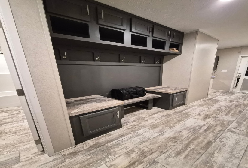 Mudroom featuring light wood-style flooring and a textured ceiling