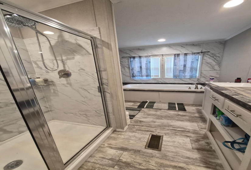 Bathroom with a bath, vanity, a marble finish shower, and recessed lighting