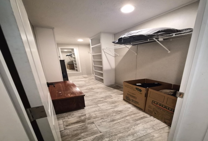 Walk in closet with light wood-style floors