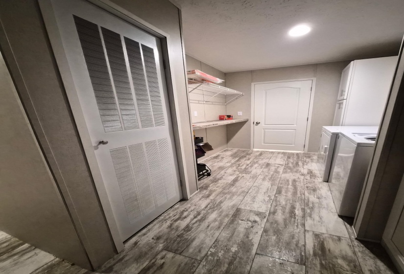 Laundry room featuring light wood-style flooring, a heating unit, and washer and dryer