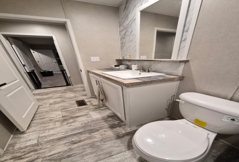 Half bath featuring vanity and a textured wall
