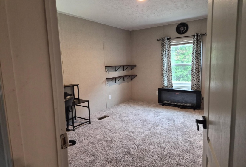 Unfurnished office featuring light colored carpet and a textured ceiling