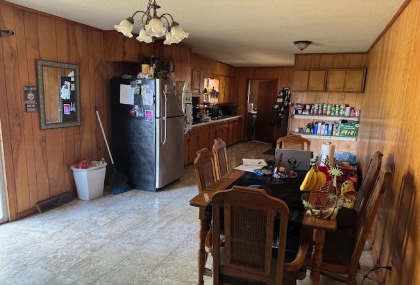 Dining space featuring light flooring, wood walls, and a chandelier