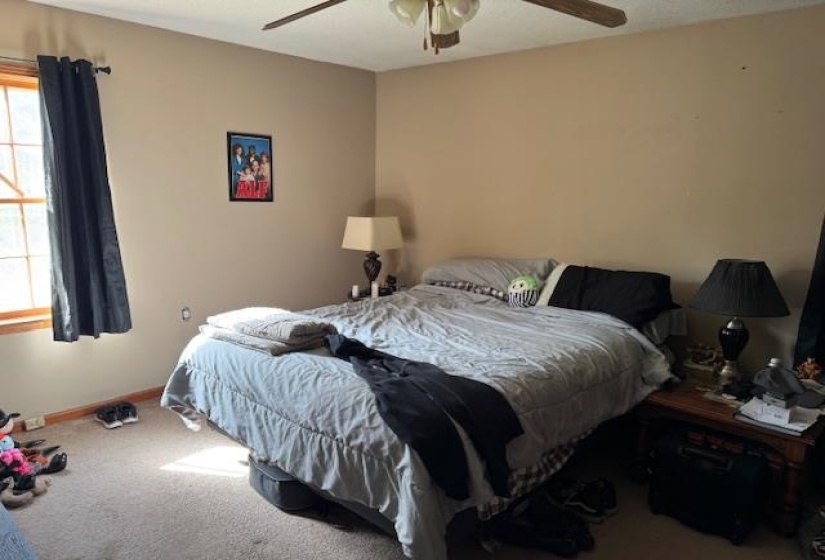 Carpeted bedroom with baseboards and a ceiling fan