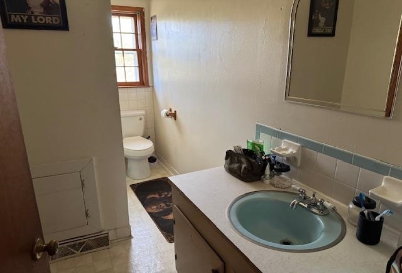 Bathroom with tile walls, vanity, and light floors