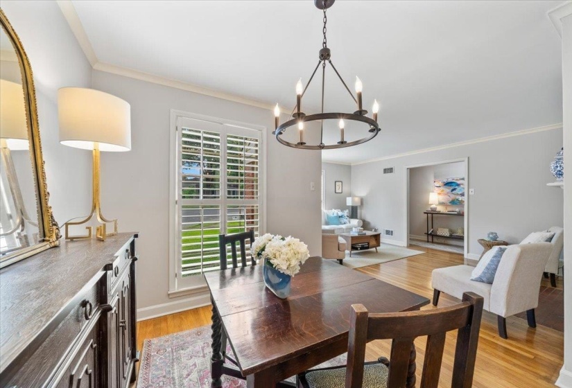 Dining room with crown molding, light wood finished floors, and a chandelier