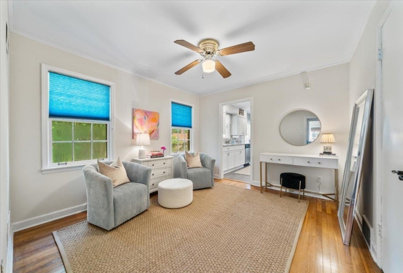 Living room featuring crown molding, light wood-style floors, and ceiling fan