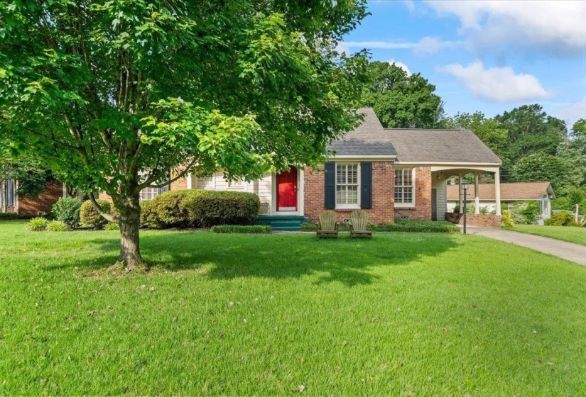 View of front facade featuring a front yard, brick siding, driveway, and roof with shingles