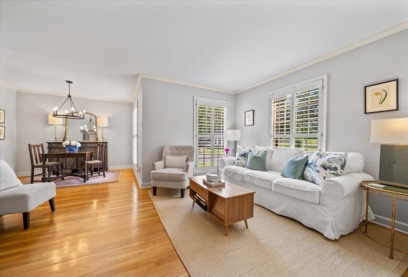 Living room featuring a chandelier, crown molding, and light wood finished floors