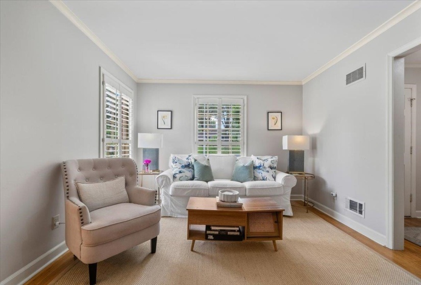 Living room with ornamental molding and wood finished floors
