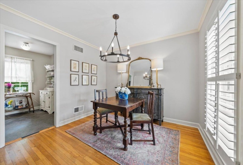 Dining area with light wood finished floors, ornamental molding, and a chandelier