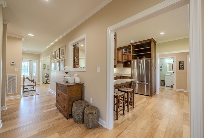 Hall with light wood finished floors, recessed lighting, and crown molding