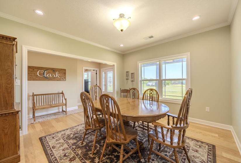 Dining room featuring light wood-style flooring, ornamental molding, and recessed lighting