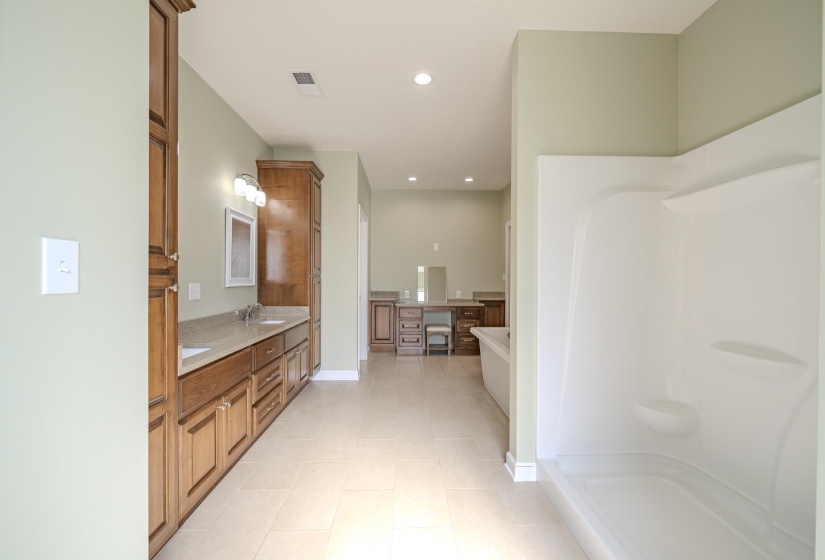 Full bathroom featuring double vanity, a soaking tub, recessed lighting, walk in shower, and light tile patterned floors