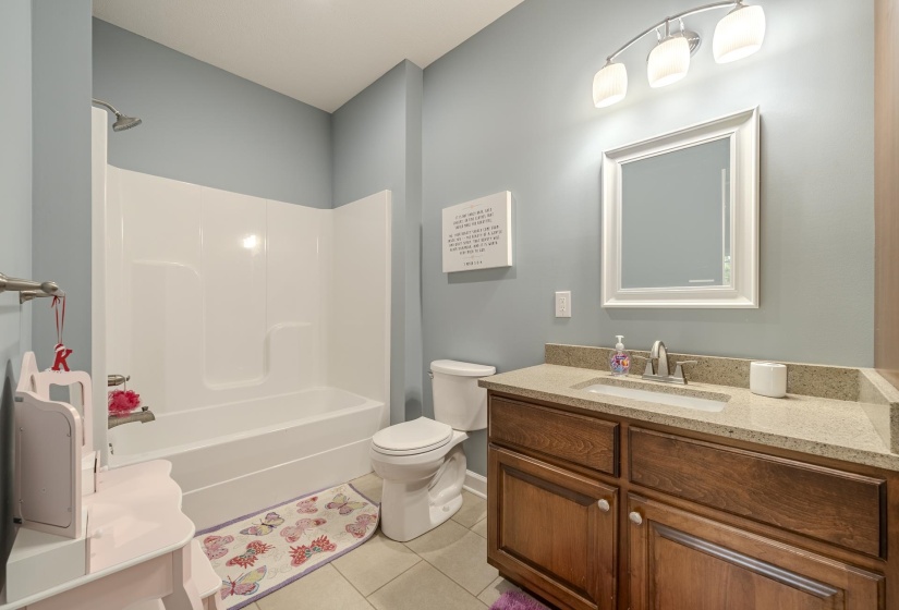 Full bath featuring vanity, washtub / shower combination, and light tile patterned floors