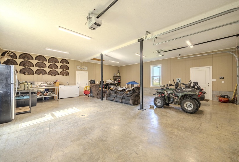 Garage featuring freestanding refrigerator and a garage door opener