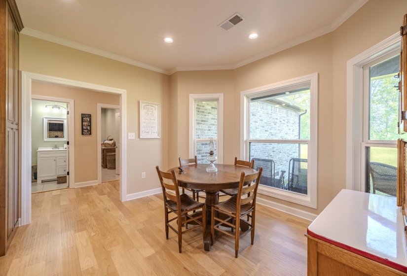 Dining area with crown molding, light wood-type flooring, and recessed lighting