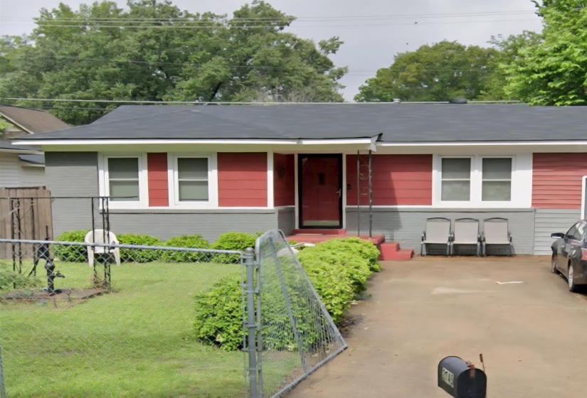 Single story home with a fenced front yard and a gate