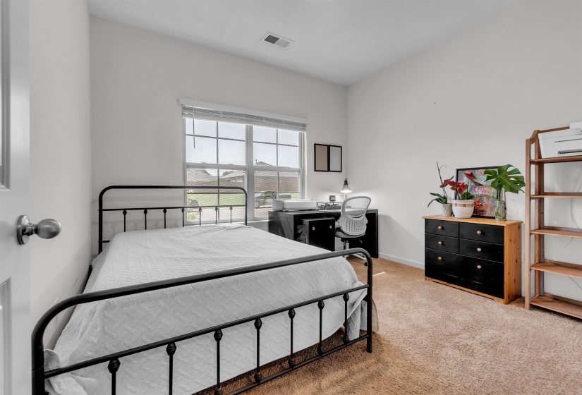 Bedroom with light colored carpet and baseboards
