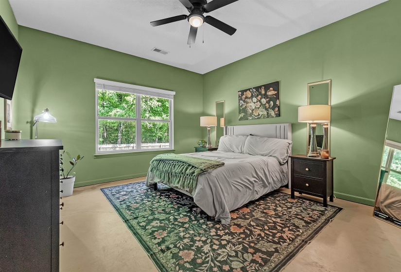 Bedroom with ceiling fan and finished concrete flooring