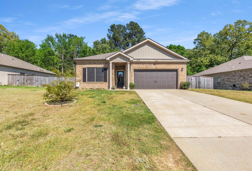 View of front of property featuring brick siding, an attached garage, and concrete driveway