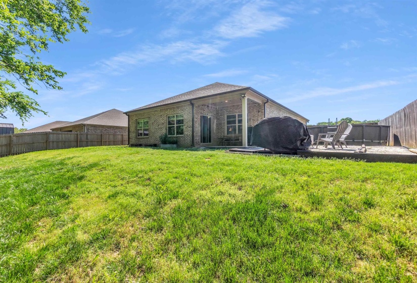 Back of property featuring a fenced backyard, a patio, and brick siding