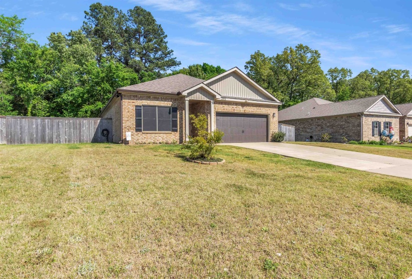 View of front of house with brick siding, concrete driveway, and a garage