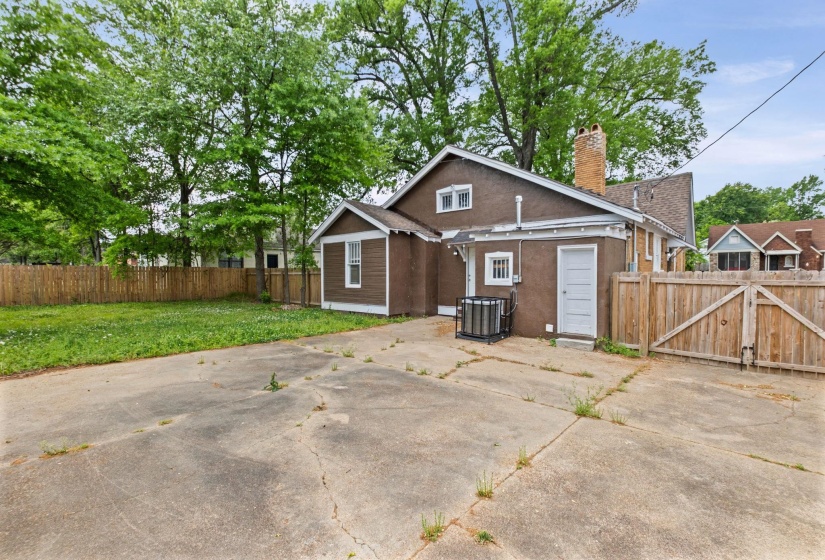 View of front of property featuring a gate, a chimney, a fenced backyard, and stucco siding