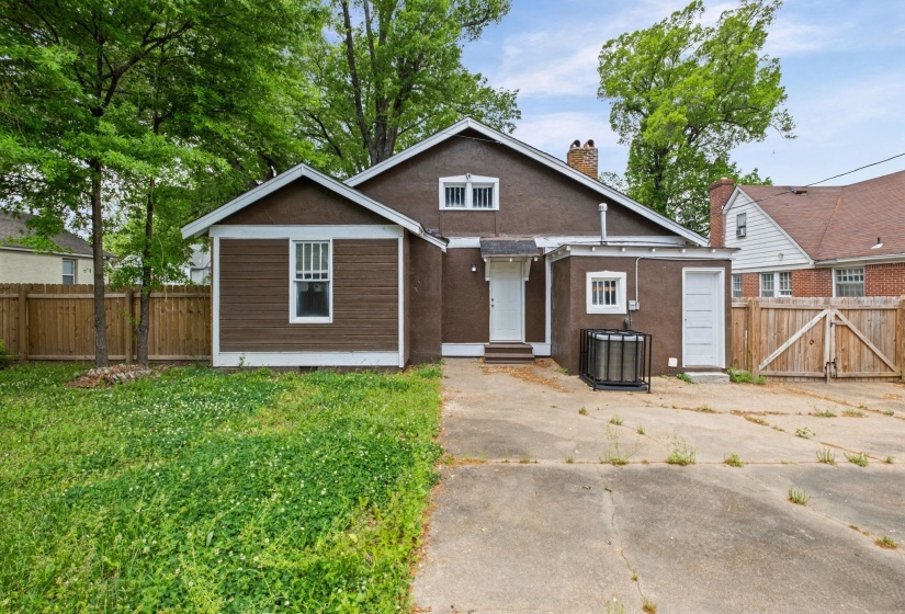 Bungalow-style home with a gate, a chimney, entry steps, and stucco siding