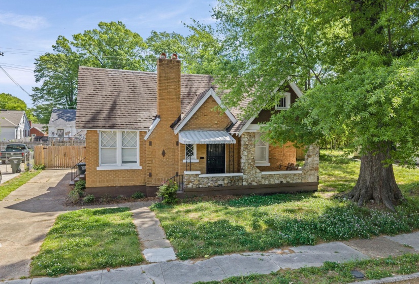 View of front facade featuring a chimney, stone siding, and brick siding