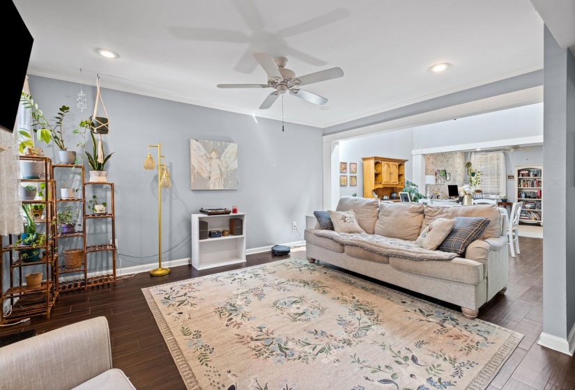 Living area with ceiling fan, dark wood finished floors, crown molding, and recessed lighting
