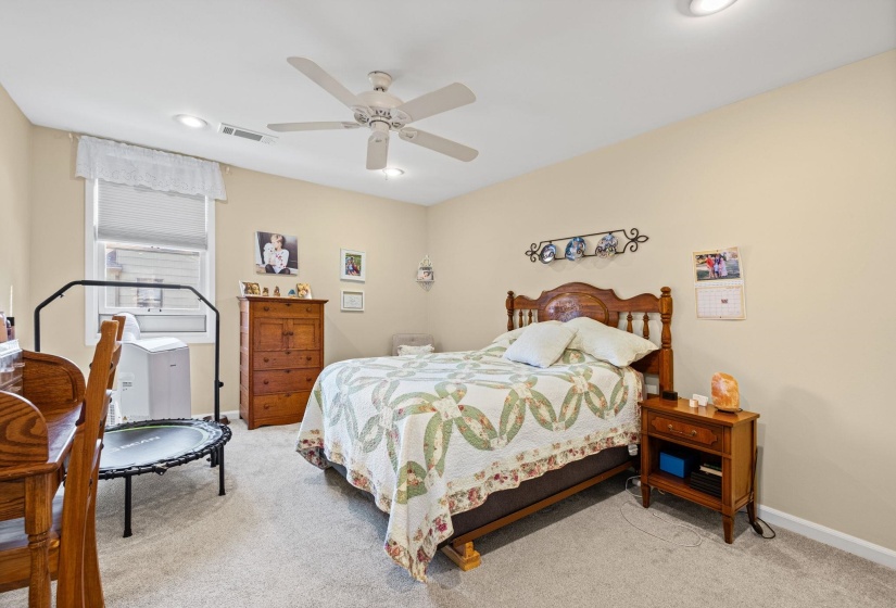 Bedroom with light carpet, ceiling fan, and recessed lighting