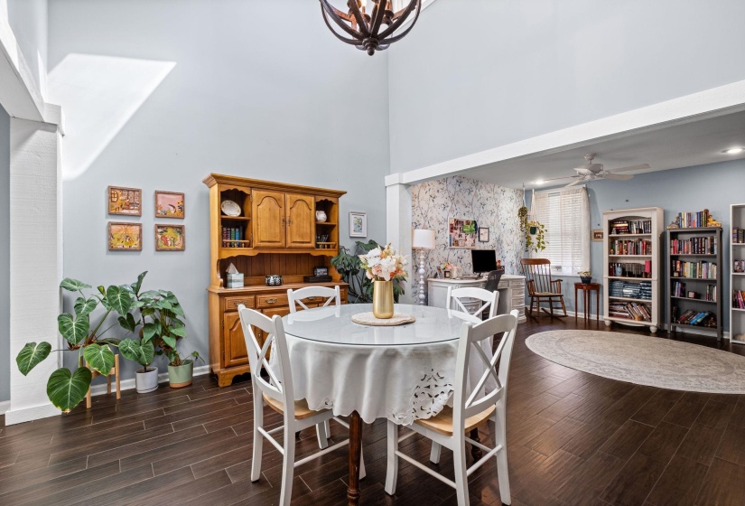Dining space featuring wood finish floors, a high ceiling, suspended lighting, and ceiling fan