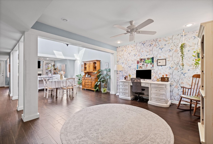 Home office with an accent wall, wallpapered walls, dark wood-style flooring, a ceiling fan, and recessed lighting