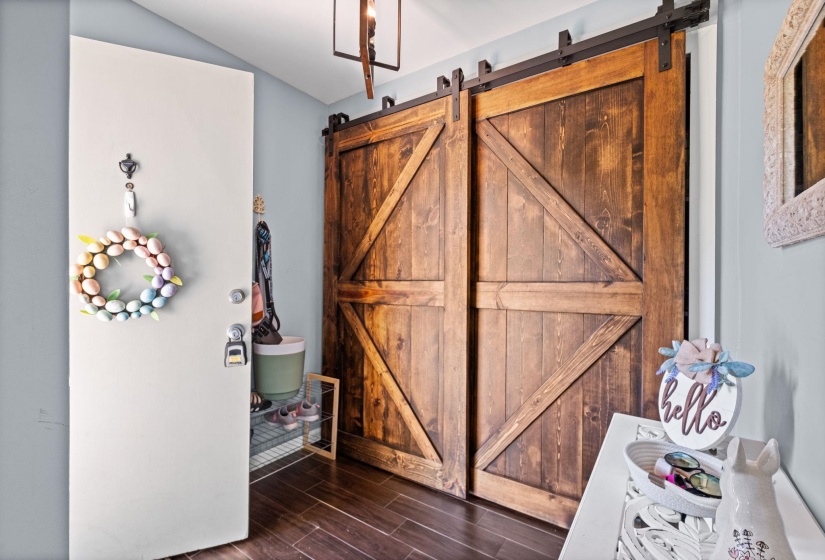 Detailed view of a barn door, wood tiled floors, and a gate