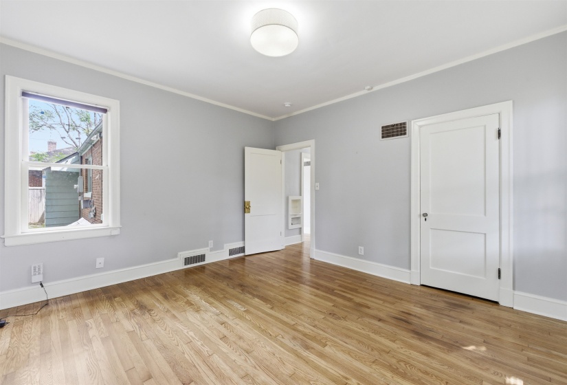Unfurnished bedroom with light wood finished floors and crown molding