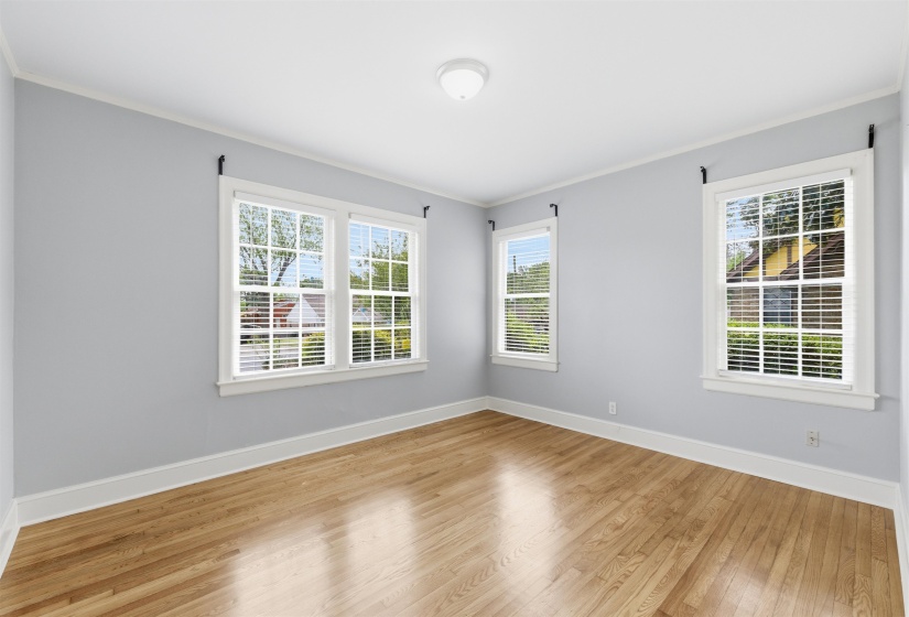 Empty room with light wood-style flooring and ornamental molding