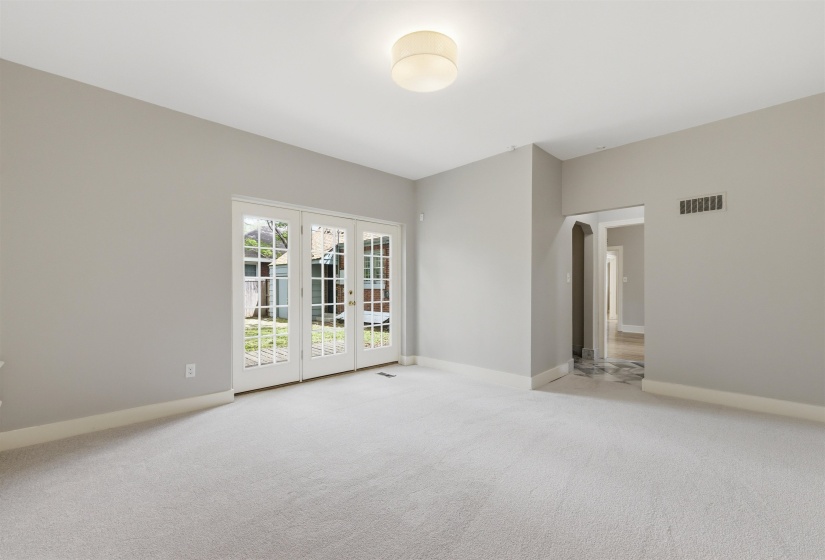 Empty room featuring light carpet and arched walkways